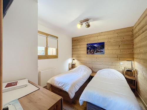 Ce lit se trouve dans un dortoir doté de murs en bois et d'une table. dans l'établissement Appartement standing à Combloux avec balcon et parking - FR-1-560-156, à Combloux