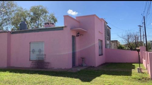 a pink house sitting on top of a yard at Casa de campo en Torres in Luján