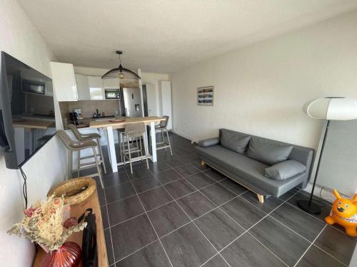 un salon avec un canapé et une cuisine dans l'établissement 2 pièces avec piscine, proche plage, parking, 4 pers - FR-1-328-271, à La Grande Motte