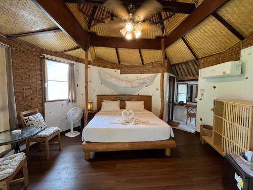 a bedroom with a bed and a table in a room at Koh Mak Cococape Resort in Ko Mak