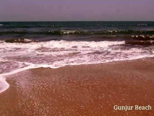 a beach with the ocean and the waves at The Gunjur Project Lodge in Gunjur