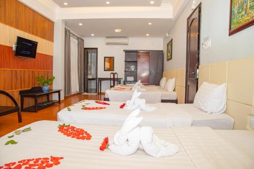 a hotel room with three beds with towels on them at Tre Xanh Hotel in Pleiku