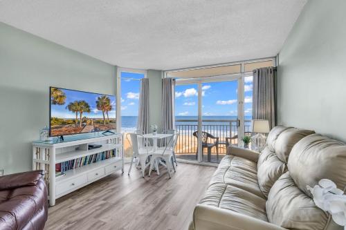 a living room with a couch and a view of the ocean at Hosteeva 1BR Oceanfront Condo in Atlantica Resort near Boardwalk in Myrtle Beach