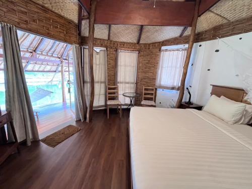 a bedroom with a bed and a large window at Koh Mak Cococape Resort in Ko Mak