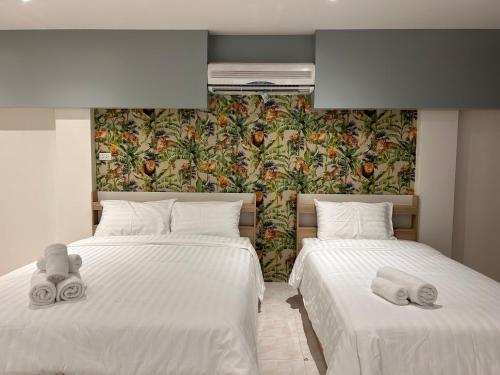 a bedroom with two beds with towels on them at Stay at 115 in Hat Yai
