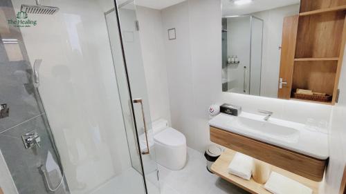 a bathroom with a toilet and a sink and a shower at The Healing Luxury Hotel in Buon Ma Thuot