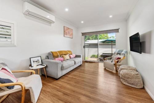 a living room with a couch and a tv at Boutique Living East Toowoomba in Toowoomba