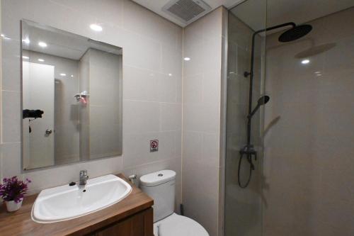 a bathroom with a toilet and a sink and a shower at Apartment Medan Podomoro City Deli by OLS Studio in Medan