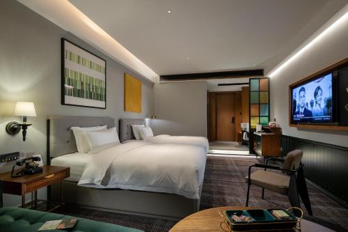 a hotel room with two beds and a flat screen tv at 林夕元酒店长沙五一广场湘雅附一店 in Changsha