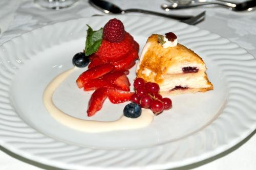 a piece of cake with berries on a white plate at Gasthof Klement in Isen