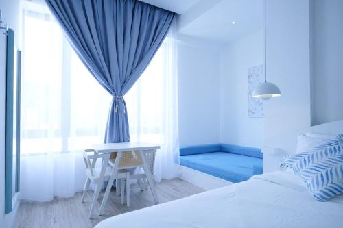 a bedroom with a bed and a table and a window at Tung Kidcove Centrum Cameron in Brinchang