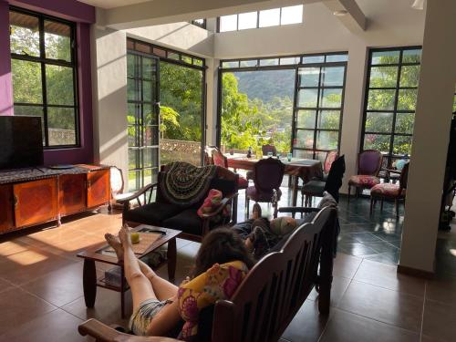 a woman laying on a couch in a living room at La Casa Morada in San Ramón