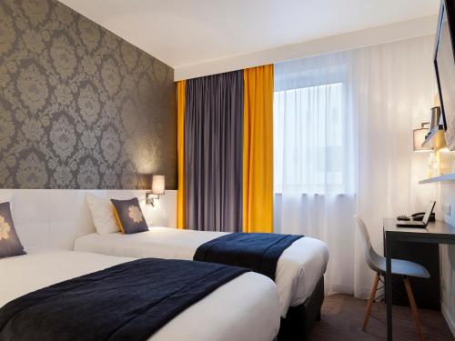 ein Hotelzimmer mit 2 Betten und einem Schreibtisch in der Unterkunft Hotel Kyriad Tours St Pierre des Corps Gare in Saint-Pierre-des-Corps