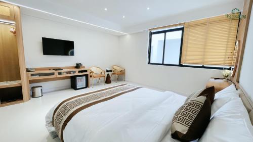 a bedroom with a large bed and a tv at The Healing Luxury Hotel in Buon Ma Thuot