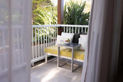 a porch with a bench and a table on a balcony at Lil Sass in Mudjimba