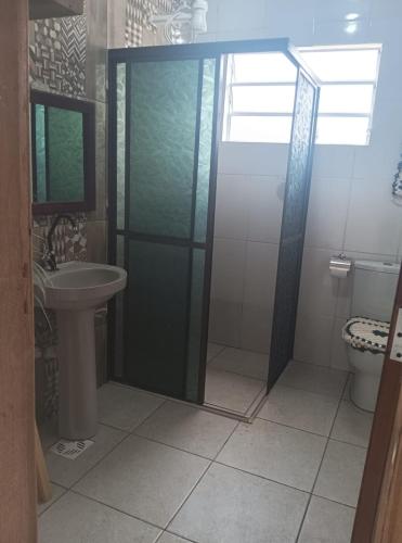 a bathroom with a shower and a toilet and a sink at Cantinho da Quinta 2 Quartos in Barra Velha