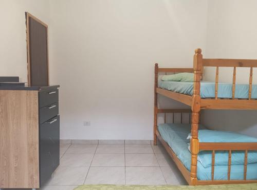two bunk beds in a room with a cabinet at Cantinho da Quinta 2 Quartos in Barra Velha