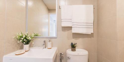 a bathroom with a toilet and a sink and a mirror at Cozy apartment near Don Mueang airport in Lak Si