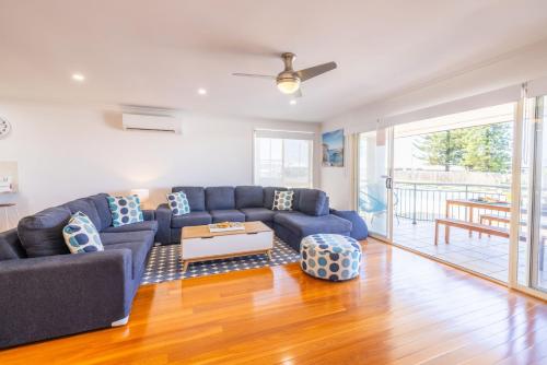 a living room with a blue couch and a table at 8 Ocean Avenue - Pet Friendly, Wi-Fi, views and Aircon in Anna Bay