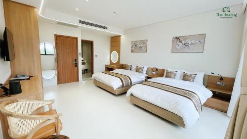 a hotel room with two beds and a bathroom at The Healing Luxury Hotel in Buon Ma Thuot
