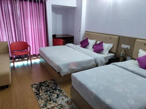 a hotel room with two beds with purple pillows at Best Southern Hotel in Kuākāta