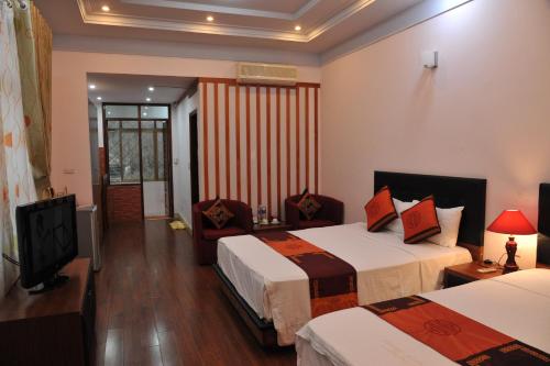 a hotel room with two beds and a television at Urban Alley Hotel in Hanoi