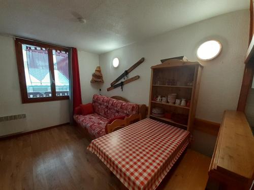 un salon avec un canapé rouge et une table dans l'établissement Studio en station avec balcon sud, proche remontées, Wi-Fi, parking gratuit - FR-1-561-136, à Modane