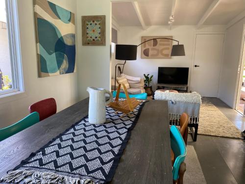a living room with a wooden table and chairs at Daffys Beach House in Suffolk Park