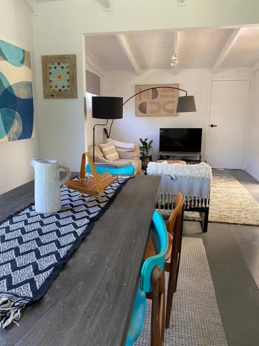 a living room with a wooden table and chairs at Daffys Beach House in Suffolk Park