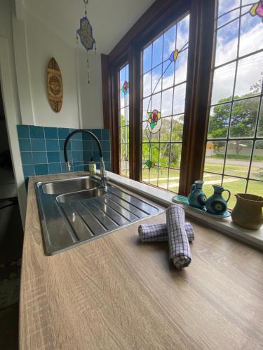 a kitchen counter with a sink and a window at Daffys Beach House in Suffolk Park