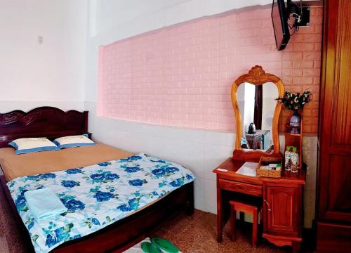 a bedroom with a bed and a dresser and a mirror at Nhà nghỉ Song Lê in Phu Quoc