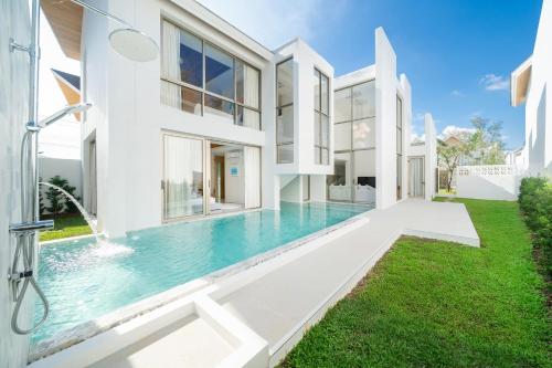 an exterior view of a house with a swimming pool at Your Private Piece of Paradise! 4BR Pool Villa in the New Lux Pride 2 V9 Residence in Bang Tao Beach