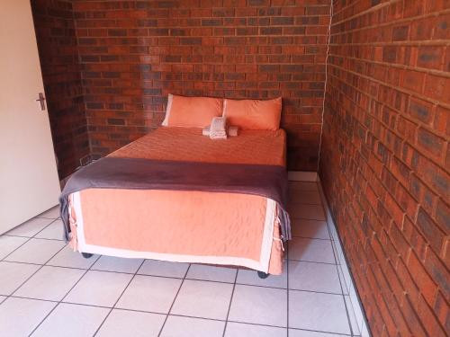 a bed in a brick room with a brick wall at Ubuntu Heaven in Germiston