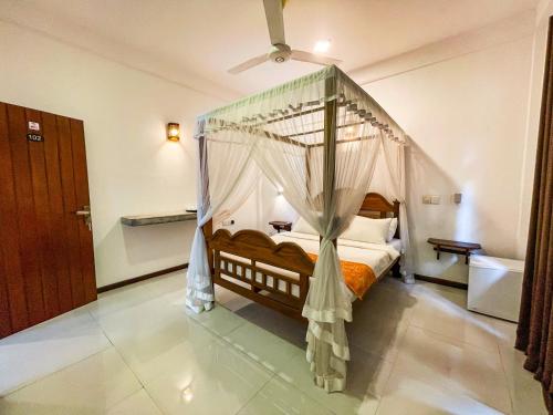 a bedroom with a bed with a canopy at Heli's Villa Unawatuna in Unawatuna