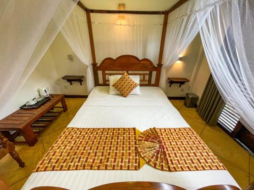 a bedroom with two beds in a room with curtains at Heli's Villa Unawatuna in Unawatuna