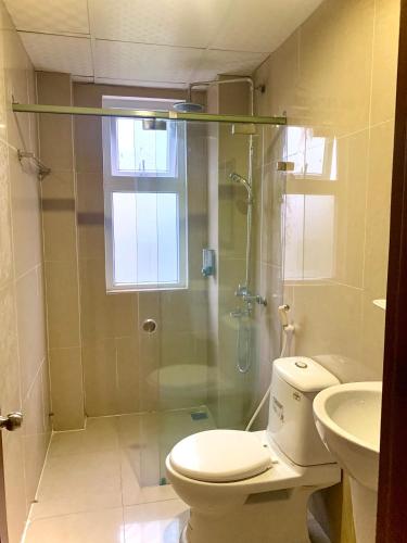 a bathroom with a shower and a toilet and a sink at Aman Riverside Hotel in Hoi An