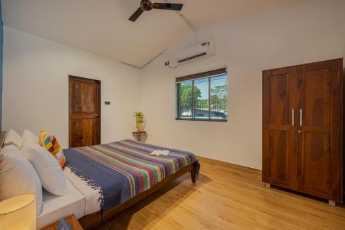 a bedroom with a bed and a window at SaffronStays Adora Woods & Hills, Luxury Pool Villa in Murud in Jambrung 