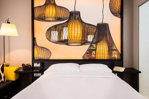 a bedroom with a bed with lights hanging above it at Simon Hotel in Fort-de-France