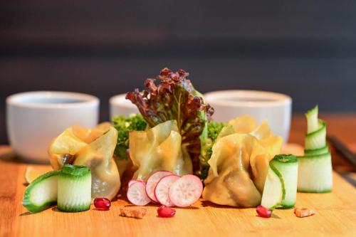 a group of dumplings and vegetables on a wooden table at Seasalter Maldives in Hulhumale