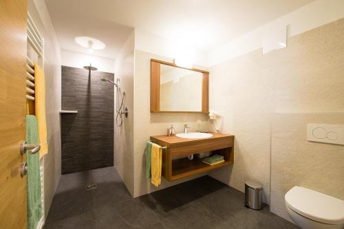 uma casa de banho com um lavatório, um WC e um espelho. em Residence Mairhof em San Leonardo in Passiria