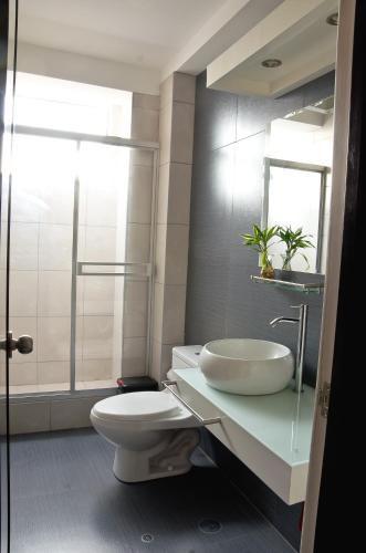 a white bathroom with a sink and a toilet at Plaza Sur Hotel & Suites in Tacna