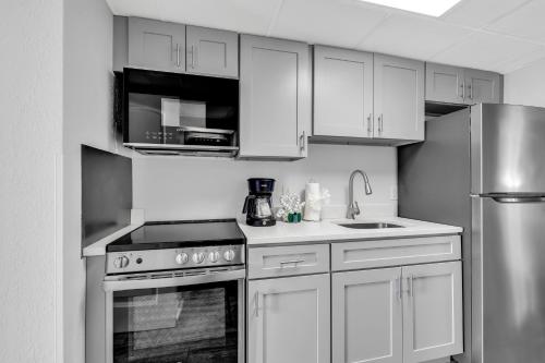 uma cozinha com armários brancos e eletrodomésticos de aço inoxidável em Boardwalk Resort Oceanfront Condo by Hosteeva em Myrtle Beach