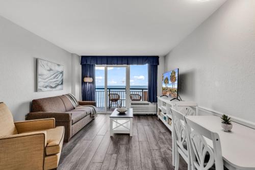 a living room with a couch and a table at Boardwalk Resort Oceanfront Condo by Hosteeva in Myrtle Beach