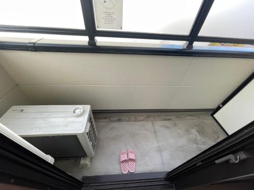 a pair of pink flip flops sitting on the floor in a room at Guest House Goettingen in Kyoto