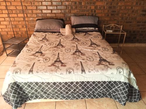 a bed with a comforter on top of it at Ubuntu Heaven in Germiston