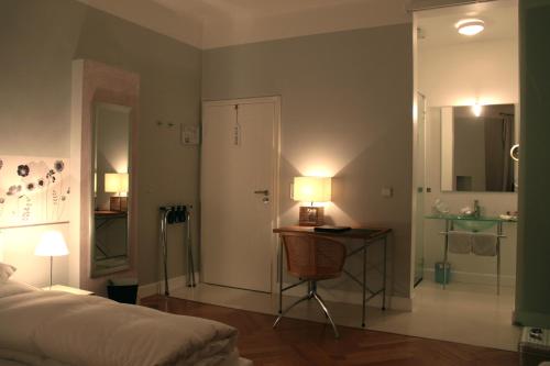 a bedroom with a bed and a desk with a lamp at Hotel Heidelberg Astoria in Heidelberg