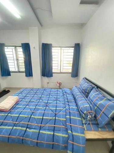 a bedroom with a bed with blue sheets and pillows at The Moonvine on 360 in Phnom Penh