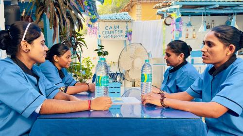 a group of nurses sitting around a table with water bottles at Viik wellness inn -3 Star Resort in Arambol Beach in Arambol
