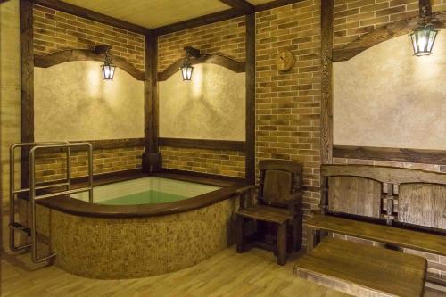 bañera de hidromasaje en una habitación de ladrillo con silla en Guest House Brest, en Brest