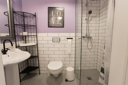 a bathroom with a toilet and a sink at Petite Visite No 18A i 18B in Toruń